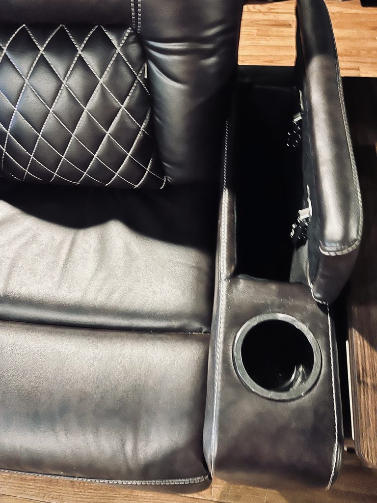 Open armrest storage and cup holder on a brown power recliner