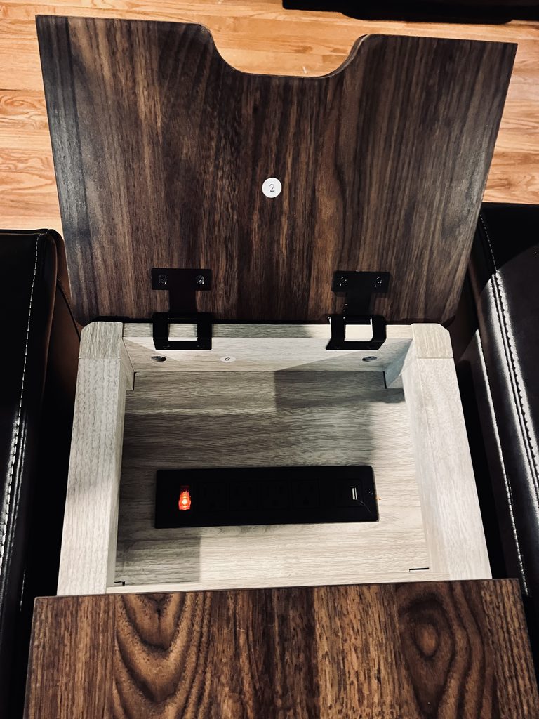 Open armrest storage and cup holder on a brown power recliner