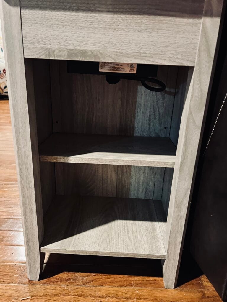Two shallow open shelves on the back of the narrow charging end table